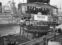 442_09 Verladung von einer fabrikneuen Dampflokomotive im Hamburger Hafen; die in den Henschel-Werken gebaute Lok wird im Ellerholzhafen am Mnckebergkai mit einem Schwimmkran von den Gleisen gehoben und zum Frachter transportiert.