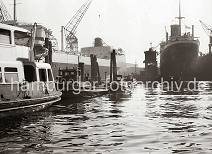 769_4 Barkassen und eine Hafenfhre am Anleger bei den Howaldswerken - am Ausrstungskai der Hamburger Werft liegt der 1954 vom Stapel gelaufene Riesentanker AL MALIK AL SAUD AWAL mit einer Tragfhigkeit von knapp 46,500 Tonnen. Im Schwimmdock liegt der britische Frachter GLENNGARRY mit Heimathafen Liverpool.