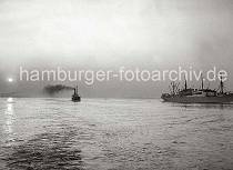 786_B_235 Zwei Frachtschiffe fahren in der Abenddmmerung auf der Elbe Richtung Hamburger Hafen - die Abendsonne spiegelt sich im Wasser des Flusses, dicker Qualm steigt aus einem Schiffsschornstein.