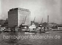 793_168 Das UNION KHLHAUS in Hamburg-Neumhlen; vor dem 1926 errichteten Gebude stehen Krne am Kai.  Eine Barkasse der Hafenpolizei fhrt entlang der Duckdalben, die im Strom stehen.