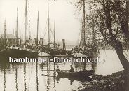 k_0954024 mehrere Fischkutter liegen bei den Landungsbrcken von Hamburg Finkenwerder - ein Ruderboot mit zwei Jungen an Bord liegt am Ufer. Im Hintergrund ein weiteres Ruderboot mit Kindern