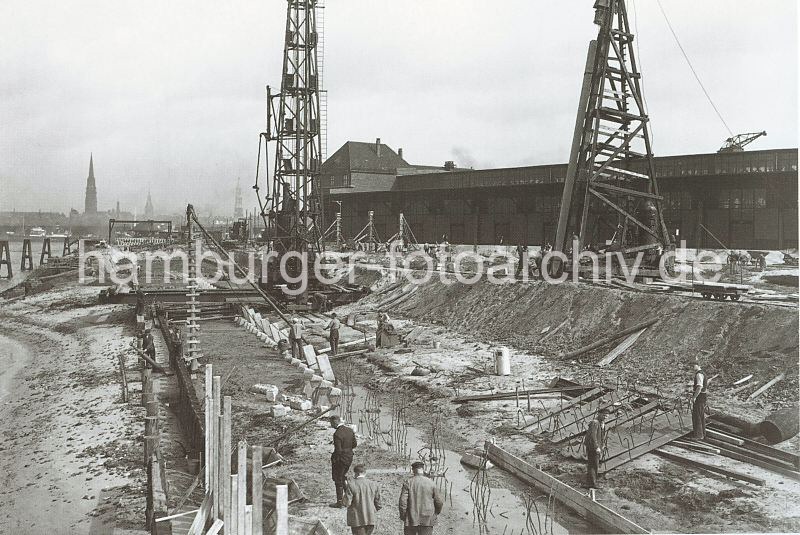 Historische Fotodokumente aus dem Bildarchiv der Hamburger Hafen und Logistik AG. Baustelle am Togokai des Sdwesthafens - Errichtung der Kaianlage - Ramme.  622_03502_58 Der alte Petroleumhafen wurde ab der 1920er Jahre zum Sdwesthafen umgebaut. Die Kaianlage des zuknftigen Togokais ist eine Baustelle. Rammen treiben Pfeiler als Unterkonstruktion des Hafenkais in den Untergrund - auf der anderen Seite der Elbe sind die Trme der Hansestadt zu sehen.