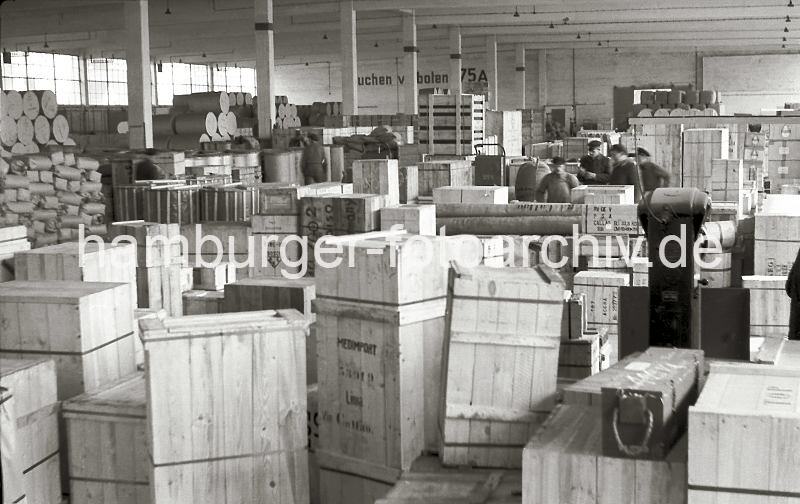 Lagerschuppen 75 im Hamburger Kaiser-Wilhelmhafen / Kronprinzenkai; ca. 1952. Alte Fotografien von der Arbeit im Hamburger Hafen aus dem - Bildarchiv der HHLA.  639_4 Blick in den dicht gef�llten Lagerschuppen 75 am Kronprinzenkai des Hamburger Kaiser-Wilhelm-Hafens. Kisten, Pakete und Ballen sind in dem gro�en Lagerraum gestapelt. Im Vordergrund stehen Holzkisten, die �ber Perus Hafenstadt Callao nach Lima exportiert werden sollen. Rechts im Hintergrund stehen Kartons mit Gl�hbirnen, die den Aufdruck Osram tragen.