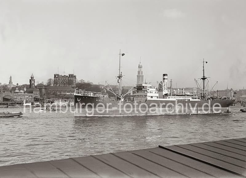 Hamburgensien, Bilder Geschenke zum Geburtstag, Jubilaeum + Weihnachten: Hamburger Elbpanorama - ein Schiff luft aus dem Hafen Hamburg aus; ca. 1930. 725_525a Blick von Hamburg Steinwerder auf die Elbe - ein Schiff verlsst den Hamburger Hafen mit Schlepperuntersttz- ung.  Dahinter das Panorama des Hamburger Elbufers beim Johannisbollwerk mit der Seewarte, Pegel- und Uhrturm, Bismarckdenkmal und dem Turm des Michels. 