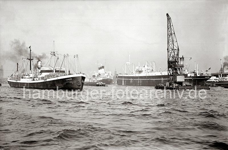 Altes Hafenfoto - Schiffsverkehr auf der Elbe - Schwimmkran + Seeschiffe; ca.1938. 736_B_308 HDas Motorschiff TANGER fhrt auf der Elbe in den Hamburger Hafen ein, das Deck ist mit Fssern und Ballen hoch beladen. Am Strandhafen liegt ein Seeschiff im Strom an den Dckdalben   - ein Schwimmkran mit Eigenantrieb ist auf dem Weg Richtung Landungsbrcken. Zwischen den Schiffen ist der Turm des Kaispeichers A zu sehen.