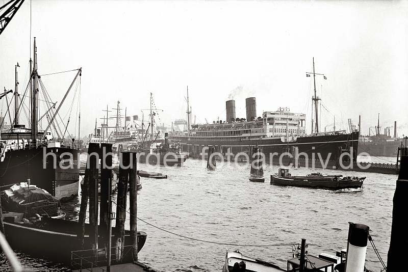 Historische Schiffsfotografien aus dem Archiv der HHLA - RMS VICEROY OF INDIA im Hamburger Hafen.  750_B_278 Die RMS VICEROY OF INDIA der Reederei Peninsular and Oriental Steam Navigation Company (P&O) liegt am Ponton im Hamburger Hafen bei den Landungsbrcken. Am Kai der Rheinschifffahrt wird gerade in der Schute eine Hieve Fsser zur Anlandung vorbereitet, dahinter das Motorschiff NEUSS mit seinen Ladebumen.