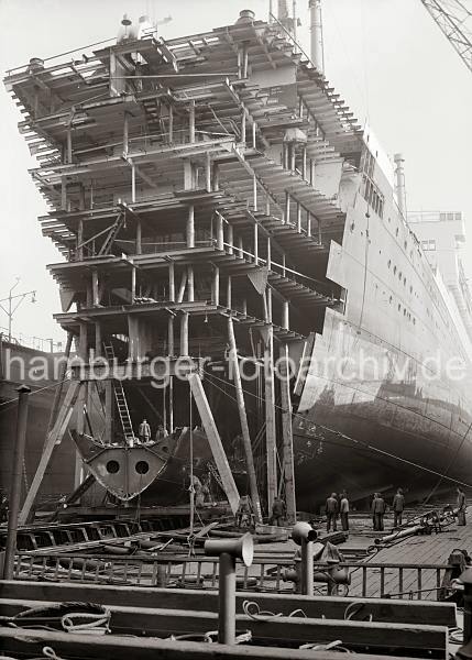 Alte Hamburger Hafenbilder Arbeit im Schwimmdock - Werft Blohm & Voss; ca.1934.  759_630 An einem Passagierschiff der HAPAG Reederei wird im Schwimmdock der Werft Bohm & Voss gearbeitet - u.a wurde 1933 das 1Turbinen-Schnelldampfer  Deutschland (IV) von 183m auf 197m auf der Hamburger Werft verlngert.