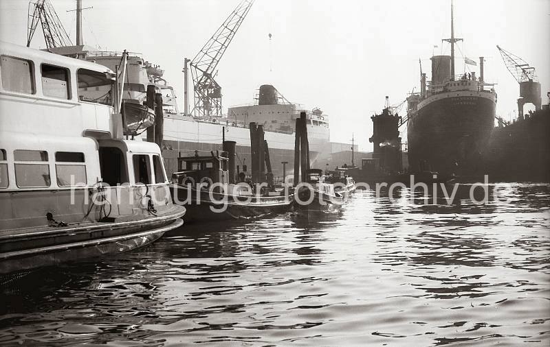 Alte Hamburg Bilder als Geschenk zum Geburtstag auf Fotoleinwand - Schiffsneubau, Tanker AL MALIK AL SAUD AWAL - HOWALDSWERKE HAMBURG AG; 1954. 769_4 Barkassen und eine Hafenfhre am Anleger bei den Howaldswerken - am Ausrstungskai der Hamburger Werft liegt der 1954 vom Stapel gelaufene Riesentanker AL MALIK AL SAUD AWAL mit einer Tragfhigkeit von knapp 46,500 Tonnen. Im Schwimmdock liegt der britische Frachter GLENNGARRY mit Heimathafen Liverpool.