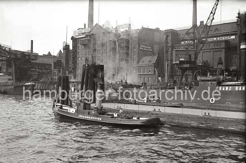 Alte Hamburger Fotos, Kohleverladung im Altonaer Hafen - Kohlefrachter lschen Ladung; ca. 1937. Geschenke fuer Hamburger: Hamburgbilder Kunstdrucke auf Leinwand + Foto-Poster.  801_B_286a An der Kaianlage von Haniel's Kohlenhof liegt ein Kohlefrachter, seine Ladung wird mit einem Kran gelscht - Kohlestaub rieselt aus dem Greifer. Links liegt das Motorschiff ELSE MLLER mit einer Ladung Kohlen tief im Wasser, das Schiff ist abgebumt, so dass noch eine Schute zwischen Bordwand und Kaimauer liegen kann, um Ladung aufzunehmen. Im Vordergrund der Schlepper TIGER der Bugsierfirma Jrgen Hinrich Steffen.