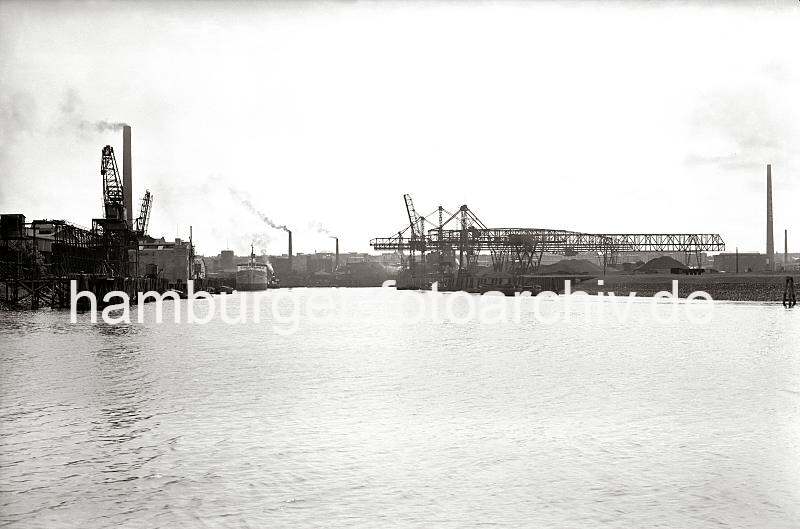 Alte Harburger Bilder - Geschichte des Hafens Harburg;  Kohlenkr�ne und Industrieanlagen am Harburger Seehafen 2.  820_B_258a Blick von der S�derelbe in den Harburger Seehafen 2; am Kai befinden sich unter den Kr�nen Kohlehalden. Auf der linken Seite des Hafenbeckens liegen Schuten und ein Seeschiff an der Kaianlage - aus hohen Fabrikschornsteinen steigt Qualm.