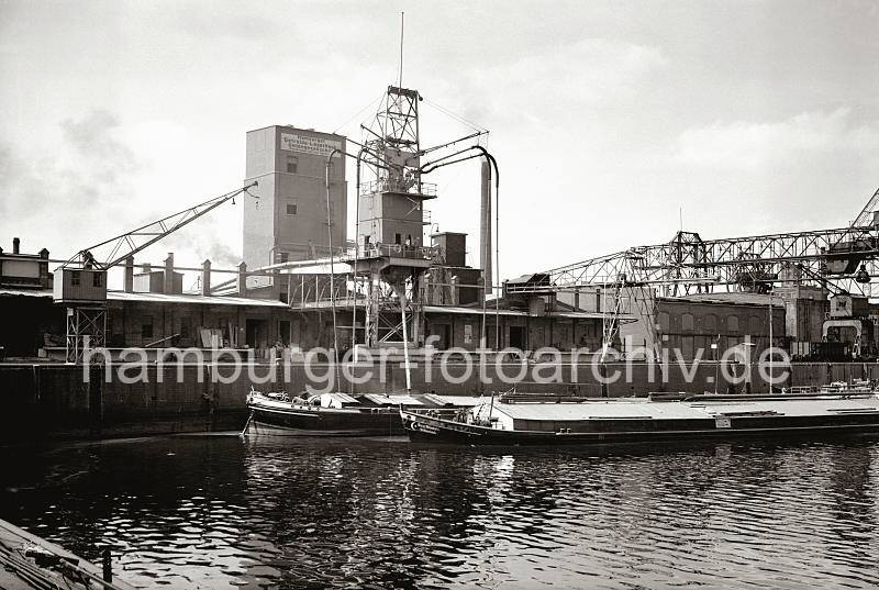 Alte Harburger Fotos - Getreideheber vor dem Silo der Hamburger Getreide-Lagerhaus Aktiengesellschaft; ca. 1938 - Alte Harburg Bilder als Geschenk zum Geburtstag, Jubilaeum + Weihnachten.  830_B_262a Zwei Elbkhne liegen vor der Privat-Kai-Anlage der Hamburger Getreide-Lagerhaus Aktiengesellschaft, Zweigniederlassung Harburg. Die Saugvorrichtungen des Getreidehebers fhren in den abgedeckten Laderaum des Binnenschiffs.