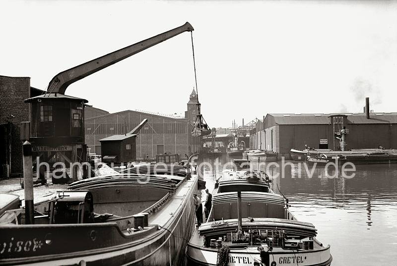 Alte Harburger Fotos - Binnenschiffe im Harburger Hafen - Rollkran auf Schienen; ca. 1938 - Alte Harburg Bilder als Geschenk zum Geburtstag, Jubilaeum + Weihnachten.  832_B_264a Binnenschiffe und Schuten haben an den Kais im Harburger Hafen festgemacht. Die Schiffer des Binnenschiffs GRETEL manvrieren ihr Schiff mit einem Bootshaken lngsseits des Elbkahns. Ein Rollkran steht am Kai, der Gterumschlage des Schttguts findet mit einem Greifer statt.