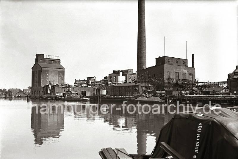 Alte Harburger Bilder - berwinterungshafen in Harburg - Thrl-Silo + Industriearchitektur; ca. 1938 - Alte Harburg Fotos als Geschenk zum Geburtstag, Jubilaeum + Weihnachten.  832_B_264a Fabrikationsanlage mit Silo und hohem Schornstein der "Thrl's Vereinigte Harburger lfabriken AG" im Harburger berwinterungshafen. Fsser liegen auf dem Kai, eine Schute wird ber eine Kippvorrichtung beladen - Kaiarbeiter fllen Scke, die auf eine Schute verladen werden.