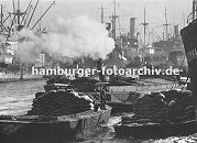 0953977 geschäftiges Treiben im Hamburger Hafen ca. 1930; Frachter liegen an den Duckdalben in der Mitte des Segelschiffhafens. Ein Schlepper zieht unter Dampf eine Schute im Hafenbecken.