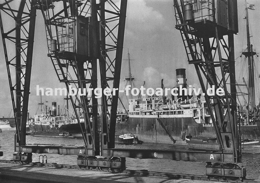 0954003 die Krne im Hamburger Hafen laufen auf Schienen -im Vordergrund der Kai Breslauer Ufer im Oderhafen. Schiffe liegen auf Reede im Hafen; Schuten und Binnenschiffe haben an der Bordwand fest gemacht. 