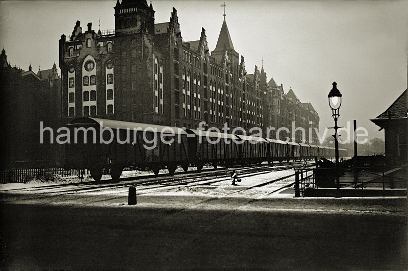 Historische Bilder von der Hamburger Speischerstadt aus dem FotoArchiv der HHLA - Nachtaufnahme vom Brooktorkai - Gterzug vor Speicherblcken V, X, Z ; ca. 1936. 01147754_OF_121 Ein langer Gterzug mit geschlossenen Waggons steht auf den Gleisanlagen des Brooktorkais. Ein Laterne leuchtet in der Nacht - auf der anderen Seite der Gleise der Hafenbahn liegt die neogotische Backstein- Architektur der Speicherblcke V, X und Z.