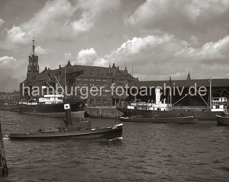 Historische Hafenmotive aus dem Fotoarchiv der Hamburger Hafen und Logistik AG. Kaispeicher, Kaiserhft - Dalmannkai und Kaischuppen 13; ca. 1934.  01160_107 Blick vom Strandhft ber die Einfahrt des Grasbrookhafens, der Schlepper Berta fhrt gerade in das Hafenbecken -  ein Motorschiff und Schuten liegen am Dalmannkai vor dem Kaischuppen 13. Links der imposante Kaispeicher A mit dem hohen Uhrenturm - vor dem feststehenden Kran hat das Frachtschiff Sutherland am Kaiserhft angelegt. Im Hintergrund sind Wohnhuser am  Johannisbollwerk und das Gebude der Seewarte zu erkennen.