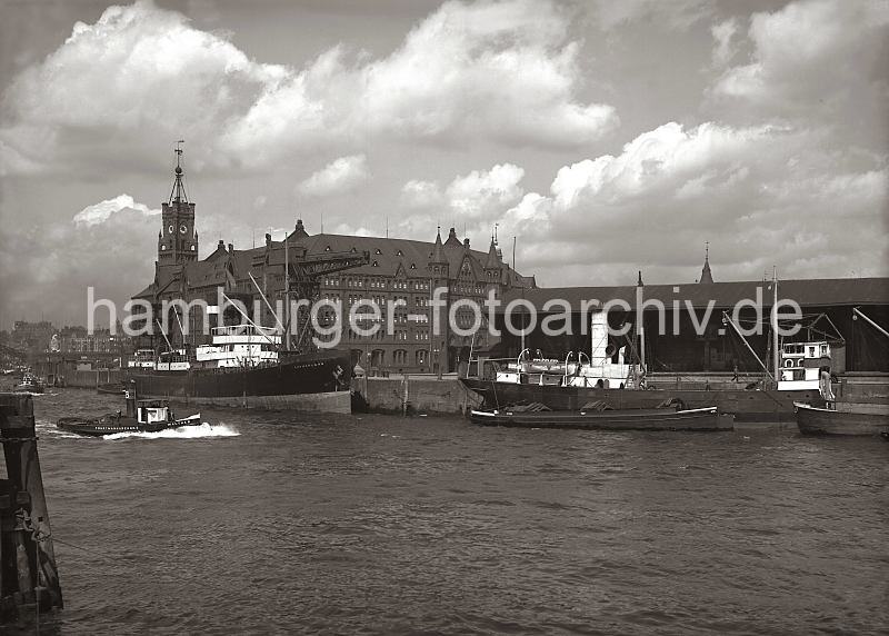 Historische Hafenanischten aus dem Fotoarchiv der Hamburger Hafen und Logistik AG. Kaispeicher, Kaiserhft - Dalmannkai und Kaischuppen 13; ca. 1934.  01161_106 Blick vom Strandhft ber die Einfahrt des Grasbrookhafens, ein Motorschiff und Schuten liegen am Dalmannkai vor dem Kaischuppen 13. Links der Kaispeicher A mit dem Uhrenturm - am Kaiserhft hat das Frachtschiff Sutherland festgemacht. Im Hintergrund sind Wohnhuser am  Johannisbollwerk und das Gebude der Seewarte hinter dem Turm der Gustav-Adolf-Kirche zu erkennen.