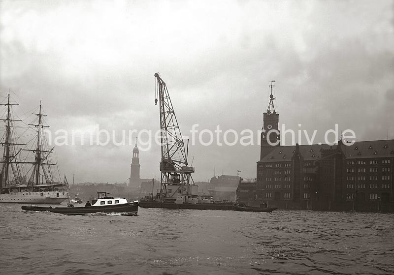 Historische Hamburg Bilder vom berseehafen -Schwimmkran auf de Elbe - Kaispeicher A, Hamburg Panorama mit Michel; ca. 1934. 01164_629 Ein 25 t Schwimmkran fhrt auf der Elbe vor Kaiserhft - lks. der Kaispeicher A / Kaiserspeicher, der 1875 fertig gestellt wurde.  Auf seinem Turm ist eine Zeitballanlage errichtet, die von der Sternwarte am Millerntor ausgelst wird. Der Ball hatte einen Durchmesser von einem Meter und wird exakt Mittags um 12.00 Uhr weit sichtbar fallen gelassen. Im Hintergrund der Turm des Hamburger Michels, die St. Michaeliskirche - das Wahrzeichen Hamburgs.