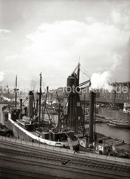 Historische Fotos aus dem Bildarchiv der HHLA. Getreideheber im Sandtorhafen, Massengutfrachter; ca.1934. Hamburgbilder auf Foto-Leinwand oder Posterprints. 02194_0079 Auf der Steuerbordseite eines Massengutfrachter liegt ein Getreideheber, der das Getreide ber die Saugleitungen aus dem lngsseits liegenden Elbkahn in den Laderaum des Dampfers umldt.