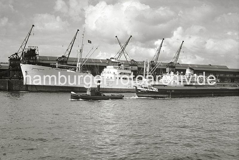 Tschechoslowakisches Binnenschiff mit Schlepper im Hamburger Baakenhafen; ca. 1937. 02241_B_249 Ein Schlepper schleppt ein Binnenschiff der tschechoslowakischen Schifffahrtsgesellschaft C.P.S.L. durch den Baakenhafen Richtung Elbe. Am Versmannkai liegt der schwedische Fruchtfrachter EGYTIAN REEFER - seine Ladung wird in den Fruchtschuppen A gelscht. 