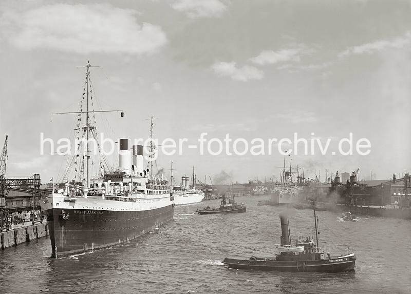 Historische Hamburgbilder des Hamburger Hafens. Passagierdampfer MONTE SARMIENTO legt ab - Schlepper SD AMERIKA  im Baakenhafen; ca. 1934. 02245_756 Der Passagierdampfer MONTE SARMIENTO legt vom Versmannkai des Baakenhafens ab - zwei Schlepper ( SD- AMERIKA VII ) ziehen den Dampfer in die Mitte des Hafenbeckens. Im Hintergrund re. ist das Gasometer der Gaswerke in Rothenburgsort zwischen den Krnen des Petersenkais zu erkennen.