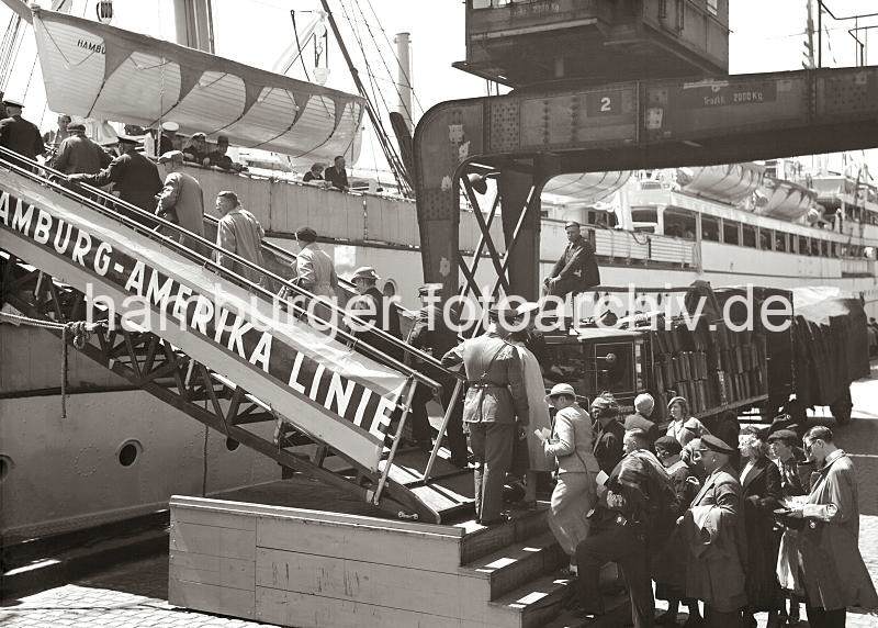 Historische Hamburgbilder des Hamburger Hafens. Passagiere auf der Gangway eines Schiffs im Baakenhafen; ca. 1934. 02247_760 Schiffs-Passagiere gehen ber die Gangway an Bord eines Passagierschiffs der Hamburg-Amerika-Linie HAPAG, das im Hamburger Baakenhafen fest gemacht hat. Von der Reling beobachten Schiffsoffiziere und andere Fahrgste das Geschehen auf dem Versmannkai. Ein Lastkraftwagen mit Anhnger steht mit Koffern der Reisenden beladen auf dem Versmannkai.