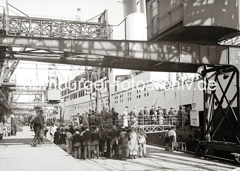 Hamburgensien aus dem Hamburger Hafen. Passagiere gehen an Bord der MONTE SARMIENTO - Hamburger Hafen; ca. 1934.  02248_756_4 Schiffspassagiere drngen sich auf dem Versmannkai vor der Gangway, um an Bord der MONTE SERVANTES zu gehen. Das 150  lange Passagierschiff konnte knapp 2500 Passagiere an Bord nehmen. Im Hintergrund werden die Koffer der Reisenden von einem Lastwagen auf dei Laderampe des Fruchtschuppens geladen.