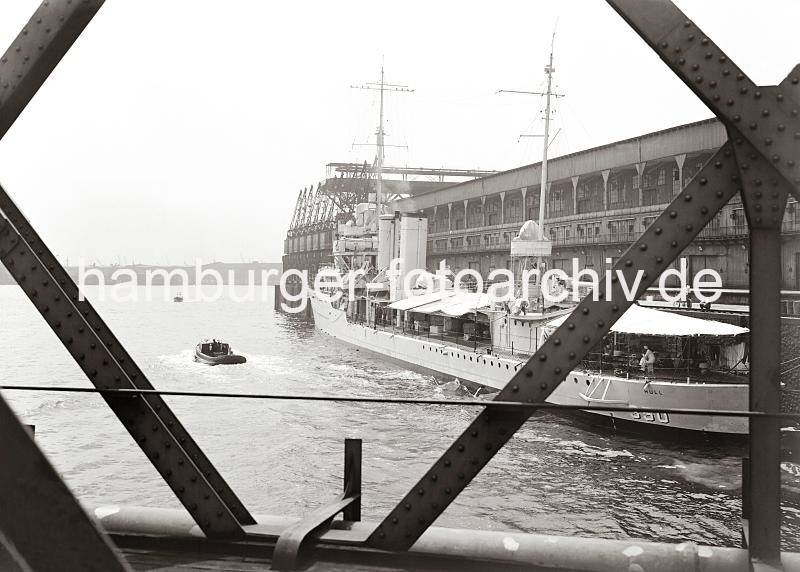 Baakenbrcke am Magedeburger Hafen - Blick auf die Norderelbe; ca. 1938. Hamburg-Hafenarchiv mit Fotos der HHLA / Hamburger Fotoarchiv Christoph Bellin. 02252_768 Blick durch die Eisentrger der Baakenbrcke auf den Magdeburger Hafen mit dem Fruchtschuppen C. Ein Marine Transportschiff hat am Kai fest gemacht. Ein Teil der Besatzung sitzt unter dem Sonnensegel am Heck des Schiffes - Besucher besteigen das Schiff ber die Gangway. Im Hintergrund das gegenber liegende Ufer der Norderelbe.