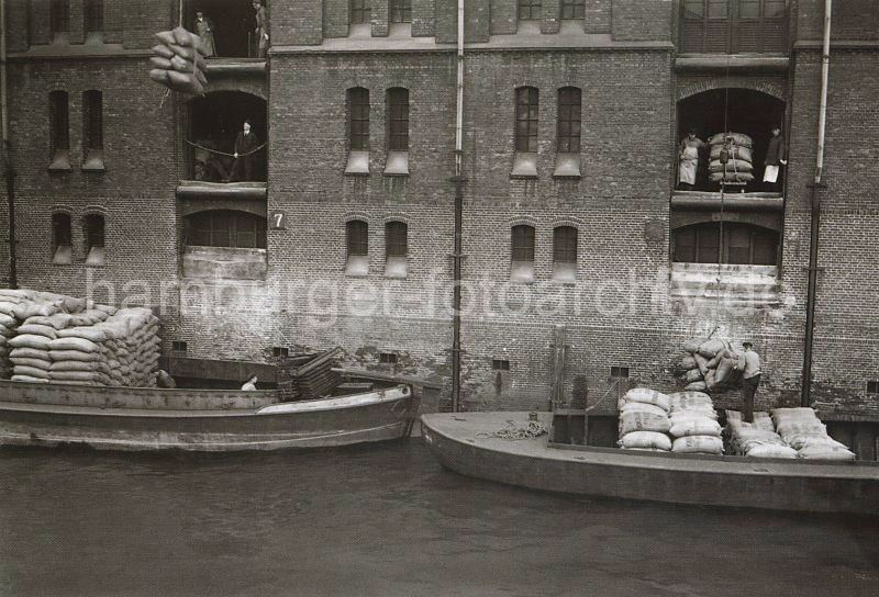 499_3502_109 Warenumschlag in der Speicherstadt - die Ladung zweier Schuten wird gelscht. Mit den Winden, die sciher unter den Dchern der Speichergebude befinden, werden die Scke auf die Bden der Lagerrume gebracht.